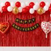 Red and white anniversary balloon decoration with red foil curtain backdrop, black gold Happy Anniversary banner, love you heart foil balloons and gold confetti balloons.