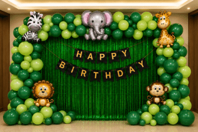 Safari theme birthday decoration with green balloon arch, animal foil balloons, green fringe curtain and happy birthday banner.
