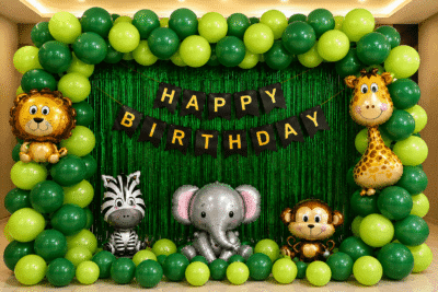 Jungle theme birthday decoration with green balloon arch, animal foil balloons, green foil curtain and happy birthday banner.