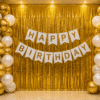 White and gold birthday decoration with metallic balloons, gold foil curtain backdrop and happy birthday banner for elegant party setup.